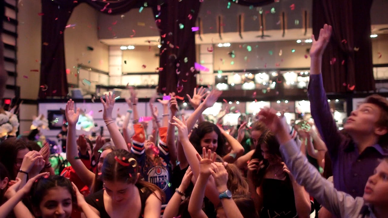 image of people waving their hands in the air at a party